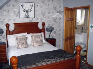 a bedroom with a bed with a deer head on the wall at Fairfield Townhouse Guest House in Inverness