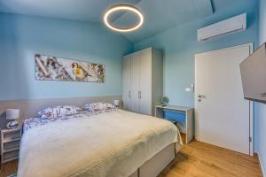 a bedroom with a large bed and blue walls at Villa AnaLucija in Labin +22 photos