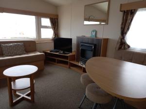 a living room with a table and a couch at Thistle 83 in Porthcawl