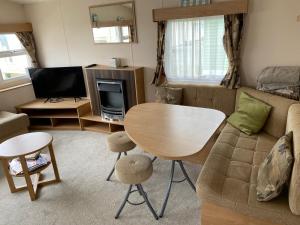 a living room with a table and a couch at Thistle 83 in Porthcawl