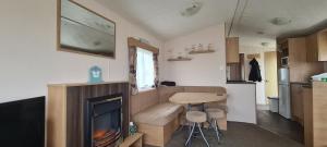 a living room with a fireplace in a tiny house at Thistle 83 in Porthcawl