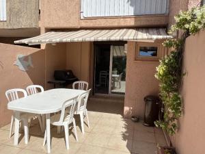 a white table and chairs on a patio at Appartement 2 Chambres avec Climatisation et Jardin, à 400m de la Plage - Les Issambres - FR-1-768-72 in La Garonnette-Plage