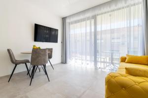Apartmani Pino 1 في باسكا فودا: غرفة معيشة مع أريكة صفراء وطاولة