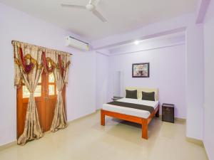 1 dormitorio con cama y ventana en Collection O Shadowline Guesthouse, en Goa
