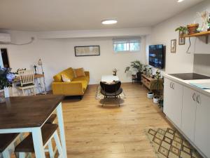 eine Küche und ein Wohnzimmer mit einem Sofa und einem Tisch in der Unterkunft המקום של מוש in Pardes H̱anna