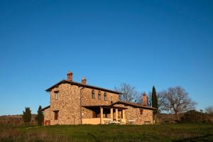 an old stone house on a hill in a field at Il casale del Mignone in Blera