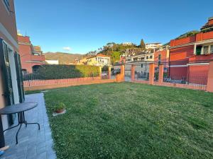 a backyard with a table and a grass yard at Santa Caterina in Levanto