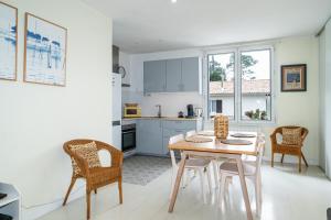 eine Küche und ein Esszimmer mit einem Tisch und Stühlen in der Unterkunft Magnifique Appartement avec parking a 300m de la Plage in La Teste-de-Buch