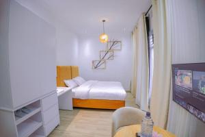 1 dormitorio con cama, mesa y TV en Makeri Residence - Musanze , Rwanda en Ruhengeri