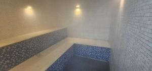 a bathroom with a tub with blue tiles on the wall at Option Full Service Residence in Rio de Janeiro