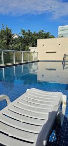 a pool with a white lounge chair on a building at Option Full Service Residence in Rio de Janeiro