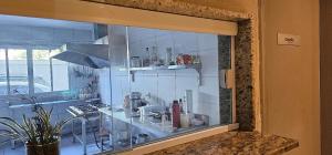 a glass window in a kitchen with a sink at Option Full Service Residence in Rio de Janeiro