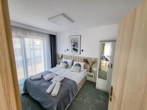 ein Schlafzimmer mit einem großen Bett mit Handtüchern darauf in der Unterkunft Hotel Gorzelanny i Apartamenty Dźwirzyno in Dźwirzyno