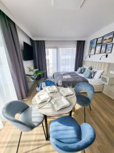 Pokój ze stołem, krzesłami i łóżkiem w obiekcie Hotel Gorzelanny i Apartamenty Dźwirzyno w Dźwirzynie
