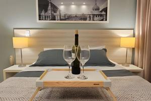 a bed with a table with two wine glasses on it at Option Full Service Residence in Rio de Janeiro