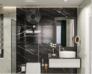 Baño de mármol negro con lavabo y espejo en Minh Dung Hotel, en Lào Cai