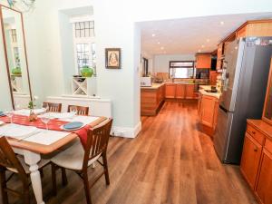 a kitchen with a table and a refrigerator at Akila in Oldham
