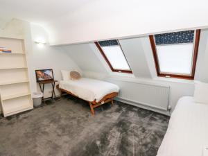 a bedroom with two beds and two windows at Akila in Oldham