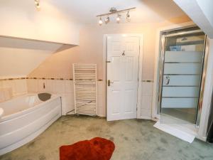 a bathroom with a tub and a shower at Akila in Oldham +49 photos