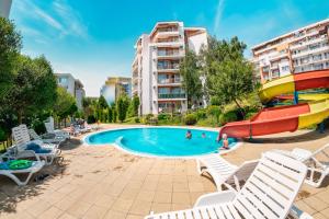 a pool with a slide and chairs and a water slide at Imperial Fort Club in Sveti Vlas