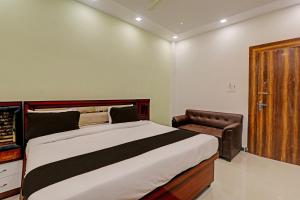 a bedroom with a large bed and a wooden door at OYO Awadh International in Pratāpgarh