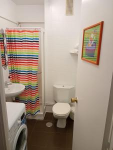 a bathroom with a rainbow shower curtain and a toilet at Pelamios Catedral in Santiago de Compostela