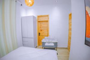 1 dormitorio con cama, mesa y puerta en Makeri Residence - Musanze , Rwanda en Ruhengeri