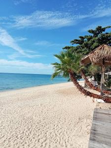 a sandy beach with a wooden boardwalk and the ocean at Amity Beach Resort in Koh Samui 