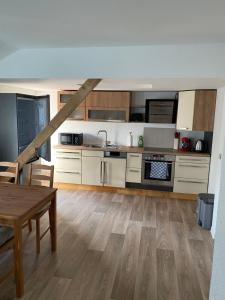 uma cozinha com armários brancos e piso em madeira em Haus Heiken em Altemburgo