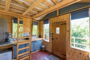 una cocina con paredes y ventanas de madera y una puerta en Cabin Westerlands en Selham