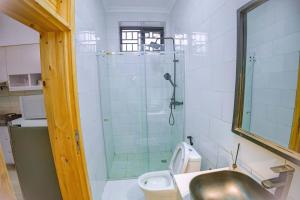 a bathroom with a shower and a toilet and a sink at Makeri Residence - Musanze , Rwanda in Ruhengeri +52 photos
