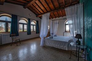 Schlafzimmer mit einem Bett mit Vorhängen und einem Tisch in der Unterkunft Il casale del Mignone in Blera