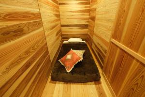 屋久島にあるKumage-gun - Glamping - Vacation STAY 73083vの木造キャビン内のベッド1台が備わる小さな客室です。