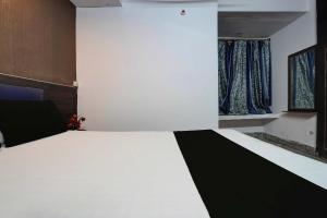 Schlafzimmer mit einem großen Bett in Schwarz und Weiß in der Unterkunft SPOT ON Hotel Drip Inn in Lucknow