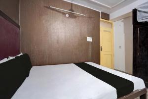 ein Schlafzimmer mit einem Bett und einer gelben Tür in der Unterkunft SPOT ON Hotel Drip Inn in Lucknow