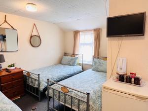 a small room with two beds and a tv at Galaxy Hotel in Blackpool