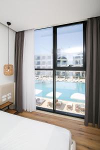 ein Schlafzimmer mit einem großen Fenster und einem Pool in der Unterkunft Oricon Coast Luxury Resort in Orikum + 37 Fotos