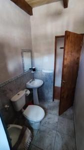 a bathroom with a toilet and a sink and a mirror at Retama in Tilcara