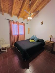 1 dormitorio con 1 cama y ventilador de techo en Chalet Villalís en Potrerillos