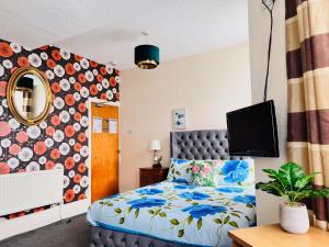 a bedroom with a bed and a tv on a wall at Galaxy Hotel in Blackpool