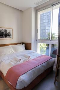 - une chambre avec un lit doté de draps blancs et une fenêtre dans l'établissement Zita Beirut, à Beyrouth