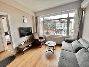a living room with a couch and a tv and a window at Kuzguncuk View in Istanbul