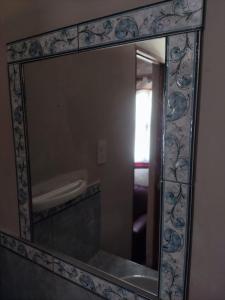 a mirror with a frame on a wall at Retama in Tilcara