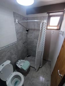 uma casa de banho com um chuveiro, um WC e um lavatório. em Retama em Tilcara