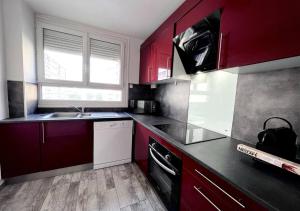 a kitchen with red cabinets and a sink at Europe in Montargis