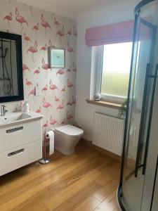 a bathroom with pink flamingos on the wall at Highmains in Dumfries