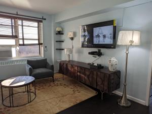 un salon avec une télévision et une chaise dans l'établissement Fully renovated Manhattan gem, à New York