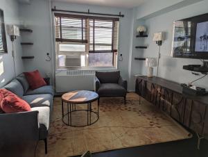 a living room with a couch and a table at Fully renovated Manhattan gem in New York