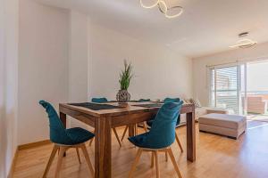 une salle à manger avec une table en bois et des chaises bleues dans l'établissement Costa Verde, à Finestrat