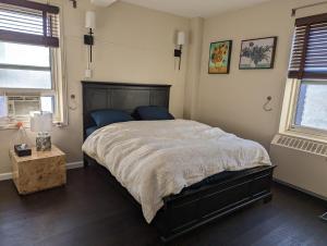 a bedroom with a large bed and two windows at Fully renovated Manhattan gem in New York